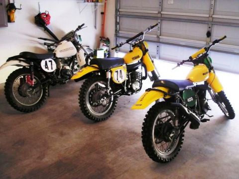 1999 Ford Ranger - A collection of vintage dirt bikes, including a Suzuki and two Yamahas, are stored inside a garage.