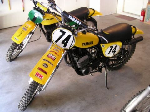 1999 Ford Ranger - Two vintage Yamaha motorcycles, both the number 74 and various racing stickers, are parked indoors.