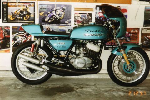 1999 Ford Ranger - A teal Kawasaki 750 Cafe Racer motorcycle is parked indoors with racing posters on the wall.