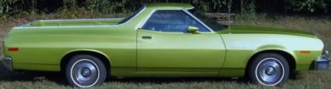 1984 Ford Mustang - This green pickup truck is viewed from the side, parked on grassy terrain.