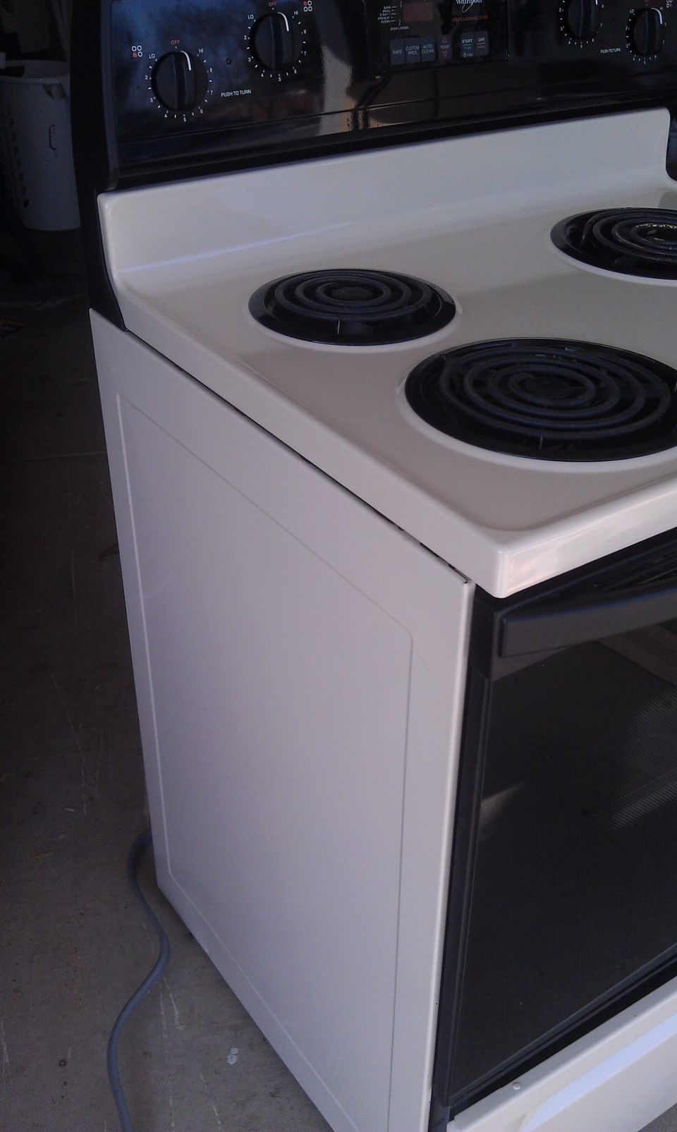 White electric range with four coil burners and control knobs