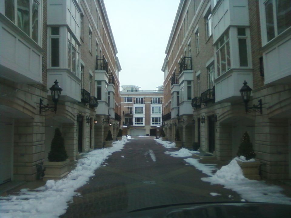 Street between townhouses with snow on the ground