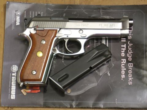 2000 Mercury Grand Marquis - A Taurus PT 100 AFS pistol is displayed with its magazine and ammunition on a patterned surface.
