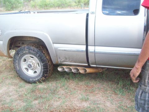 1989 Ford Bronco - Pickup truck with custom quad exhaust pipes visible on the side.