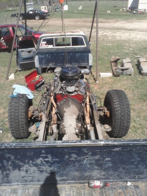 1989 Ford Bronco - A pickup truck's body is suspended by a crane while its engine and transmission are removed from the chassis.