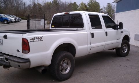 2002 Ford F-250 - This white 2002 Ford F-250 Super Duty pickup truck is seen from a three-quarter front angle, parked in a lot.