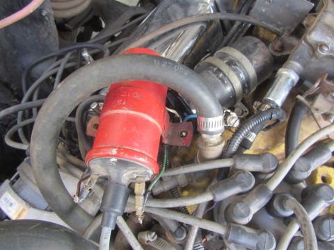 1964 Ford Ranchero - Close-up view of an engine bay, focusing on a red ignition coil and associated wiring.