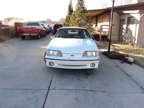 1989 Ford Mustang - Front view of a white Ford Mustang with some damage to the front bumper.