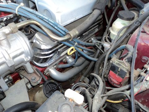 1989 Ford Mustang - Close-up view of a car's engine bay, showing various mechanical parts and wiring.