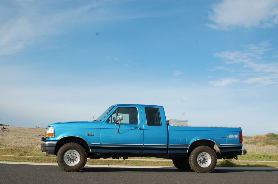Blue 1992 Ford F-150 truck, side view, with a toolbox in the bed