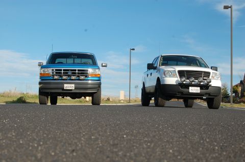 1992 Ford F-150 - Two Ford F-150 trucks are parked on a road under a clear blue sky.