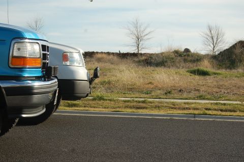 1992 Ford F-150 - Two trucks, a blue Ford F-250 and a silver truck, are parked side-by-side on an asphalt road.