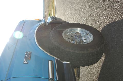 1992 Ford F-150 - A blue 1992 Ford F-150 is shown from the side, chrome trim and aftermarket wheels.