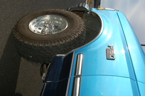 1992 Ford F-150 - Close-up of a blue 1992 Ford F-150 fender showing the F150 badge and a spare tire.