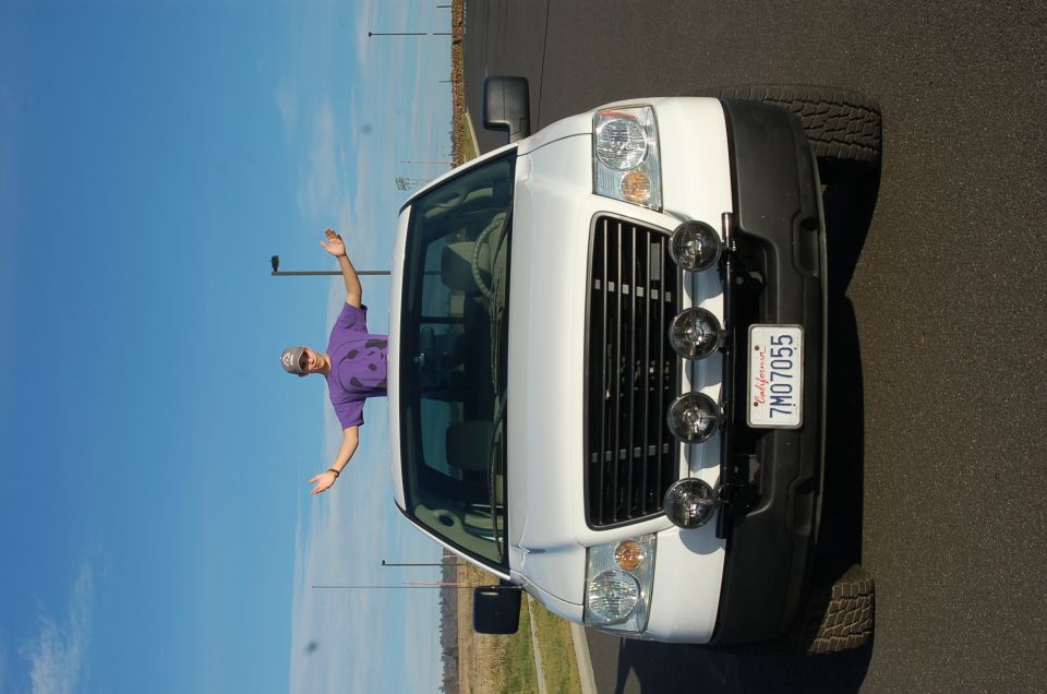 White pickup truck with a person leaning out the window. Has a California license plate