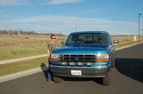 1992 Ford F-150 - Front view of a blue 1992 Ford F-150 pickup truck with a person standing beside it.