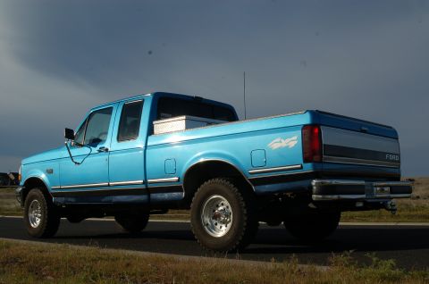 1992 Ford F-150 - This blue 1992 Ford F-150 pickup truck is seen from the rear three-quarter view on a cloudy day.