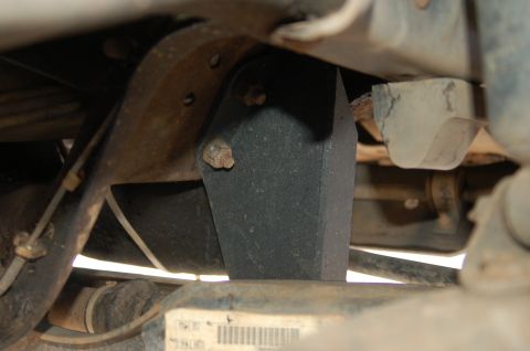1992 Ford F-150 - Close-up of a vehicle's undercarriage shows a black rubber bump stop attached to a rusty bracket.