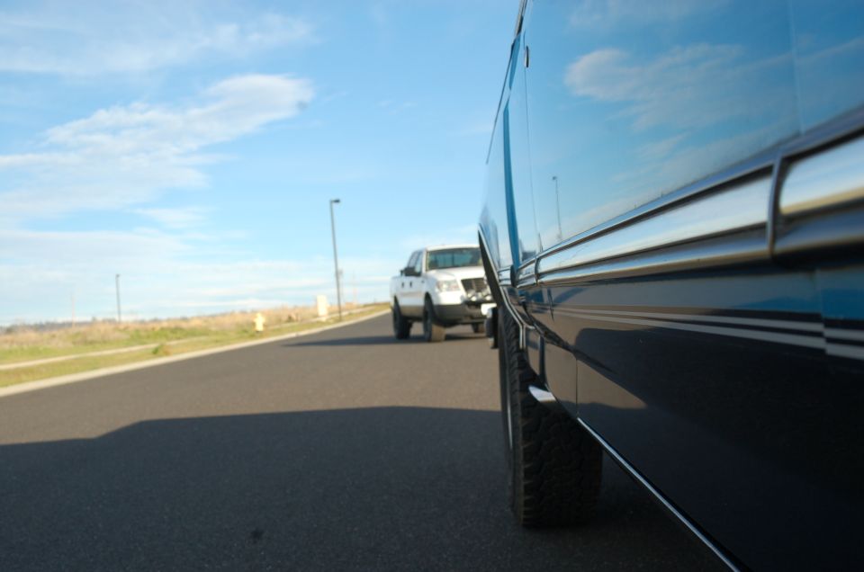 White 1992 Ford F-150 driving on a road, seen from the side of another vehicle