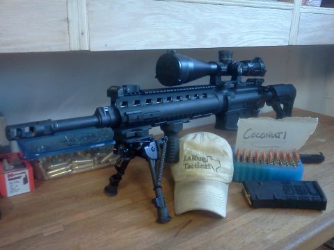 1996 Ford Bronco - Rifle with scope, bipod, magazine, ammunition, and a tactical hat on a wooden surface.