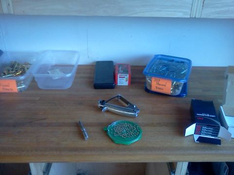 1996 Ford Bronco - Various ammunition reloading components are organized on a workbench, including brass casings and primers.