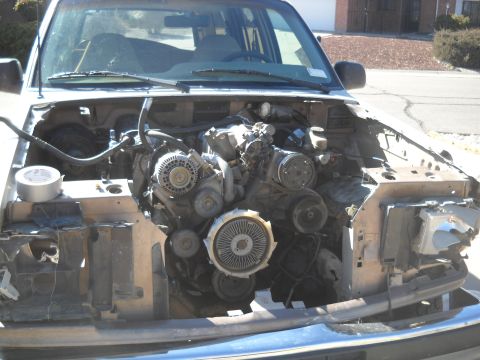1992 Ford Explorer - The front of a vehicle is open, revealing the engine and surrounding components. The vehicle appears to be undergoing repairs or disassembl…