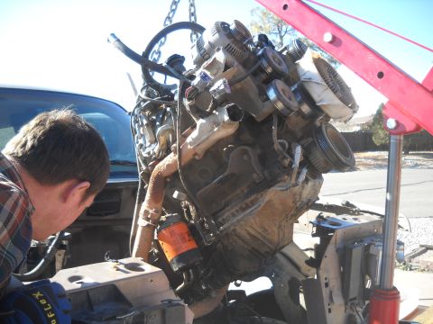 1992 Ford Explorer - Engine removal in progress, with a person assisting the hoist operation.