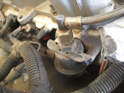 1992 Ford Explorer - Close-up of an engine fuel pressure regulator and braided fuel line.