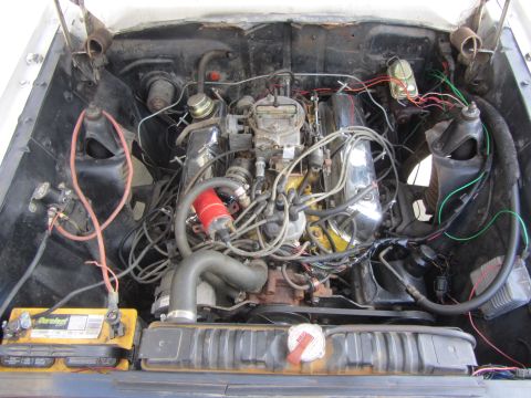 1964 Ford Ranchero - The engine bay of a classic vehicle, showing the V8 engine and its components.