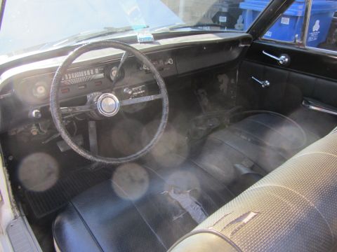 1964 Ford Ranchero - Interior view of a 1964 Ford Ranchero, highlighting its aged condition with a cracked dash and torn seat.