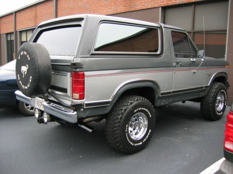 1986 Ford Bronco - This 1986 Ford Bronco features a two-tone gray paint scheme and a spare tire mounted on the rear door.