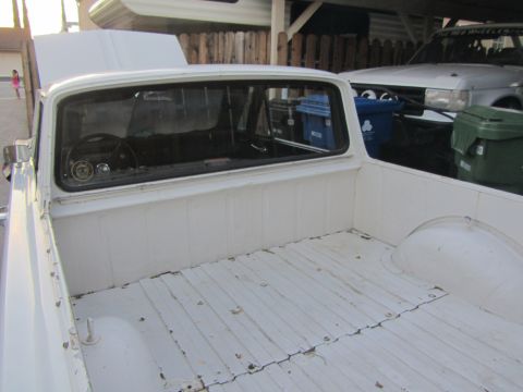 1964 Ford Ranchero - View of the interior and bed of a white 1964 Ford Ranchero pickup truck.