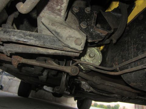 1964 Ford Ranchero - A detailed look at the undercarriage of a vehicle, revealing its mechanical components and signs of age.