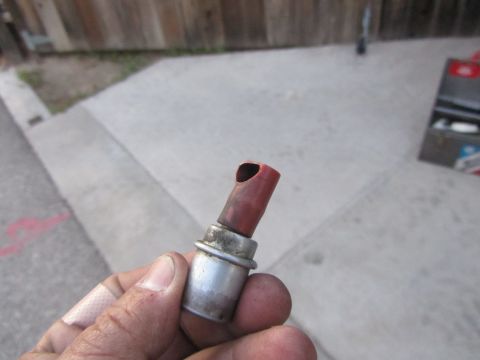 1964 Ford Ranchero - A close-up shows a red rubber hose fitting with a metal base being held by a hand.