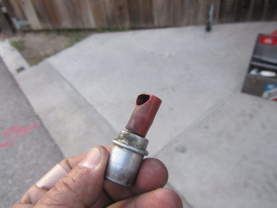 Red rubber hose fitting with metal base held in hand