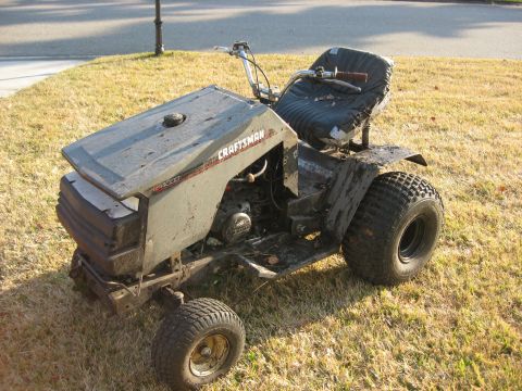 2010 Kawasaki BAYOU 220 - This Craftsman riding mower appears to be in a state of disrepair, with a worn seat and mud-splattered body.