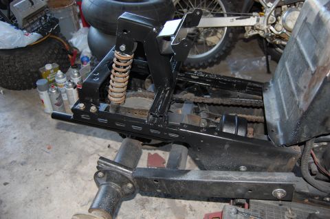 2010 Kawasaki BAYOU 220 - Close-up of an ATV frame section, showing suspension and drive chain components.