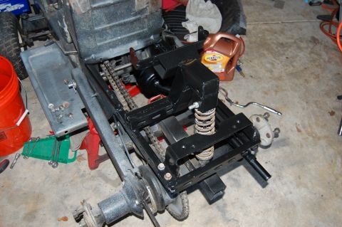 2010 Kawasaki BAYOU 220 - The rear axle assembly of a lawn tractor is shown in a garage setting, with various tools and parts visible.