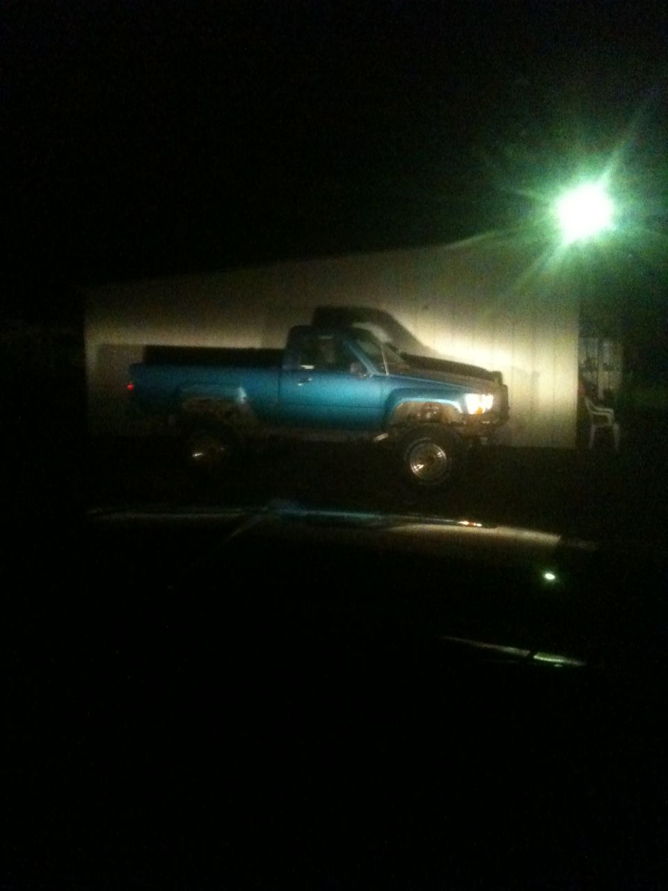 Blue 1988 Toyota Hilux pickup truck parked at night