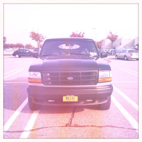 1992 Ford Bronco - This 1992 Ford Bronco is parked in a lot, facing the camera directly.