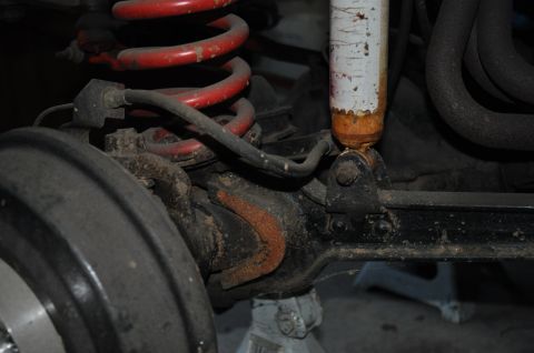1974 Ford Bronco - This image shows a close-up of a vehicle's suspension system, focusing on rusty components and a shock absorber.
