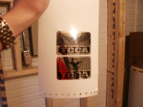 1998 Mercury Sable - A white cylindrical object displays two metallic stickers, one with text and the other with a bull graphic.