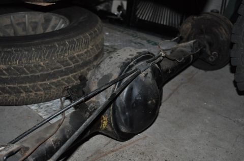 1974 Ford Bronco - A spare tire rests next to a rear axle assembly, with the SuperMotors.net logo visible in the corner.