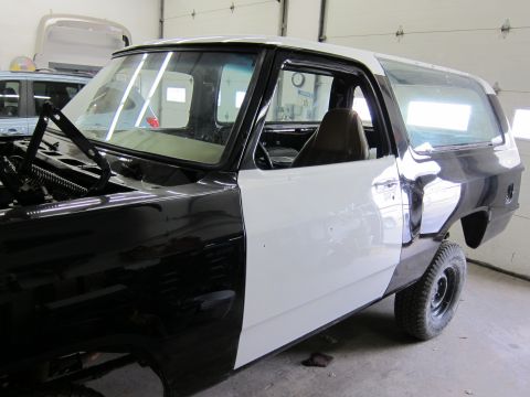 1987 Dodge 1500 - This 1987 Dodge Ramcharger is in a garage, showing its bodywork in progress with primer and black paint.
