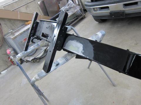 1987 Dodge 1500 - A metal frame, possibly a bumper or chassis component, is being worked on in a garage setting.