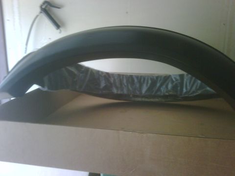 1996 Ford Bronco - A black plastic fender flare is shown inside its packaging and box.
