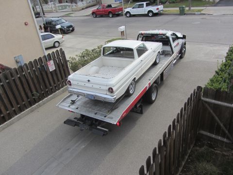 1964 Ford Ranchero - White 1964 Ford Ranchero on a tow truck, viewed from the rear.