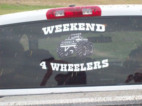 1989 Ford Bronco - A white truck's rear window displays a "WEEKEND 4 WHEELERS" sticker with a monster truck graphic.