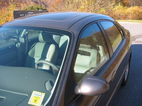 2003 Ford Taurus - The interior of a sedan is visible, parked near a scenic overlook with autumn foliage.