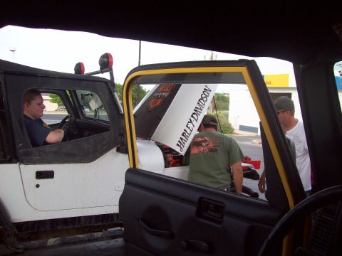 1989 Ford Bronco - Two Jeep Wranglers are parked with their hoods open, one displaying a Harley Davidson decal.